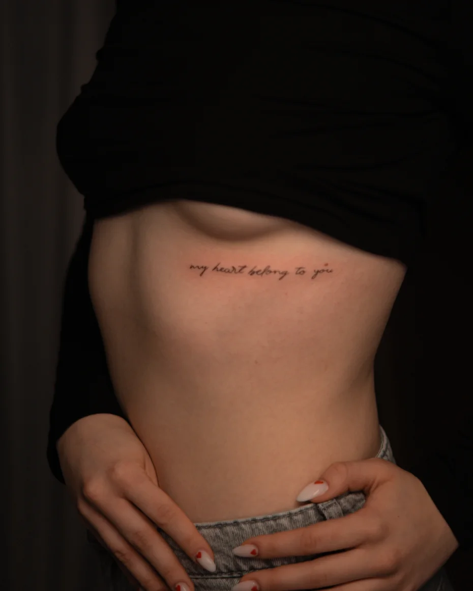 Delikatny napis my heart belongs to you na boku tułowia